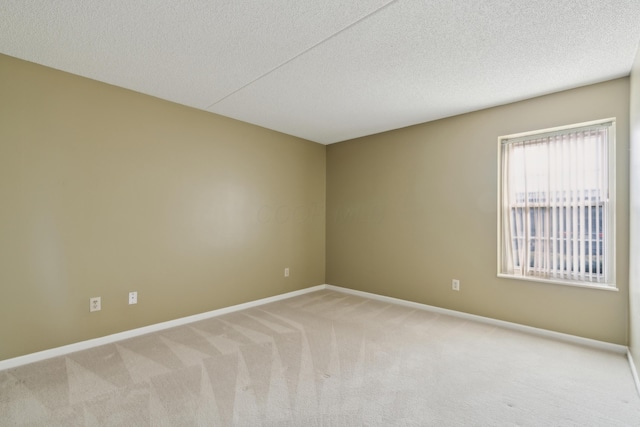 empty room with carpet flooring and a textured ceiling