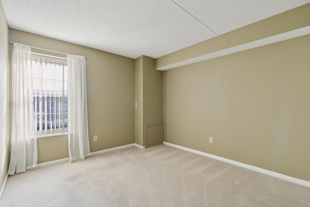 carpeted empty room featuring a textured ceiling