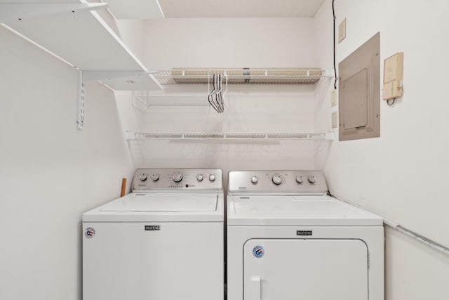 clothes washing area with electric panel and washing machine and dryer