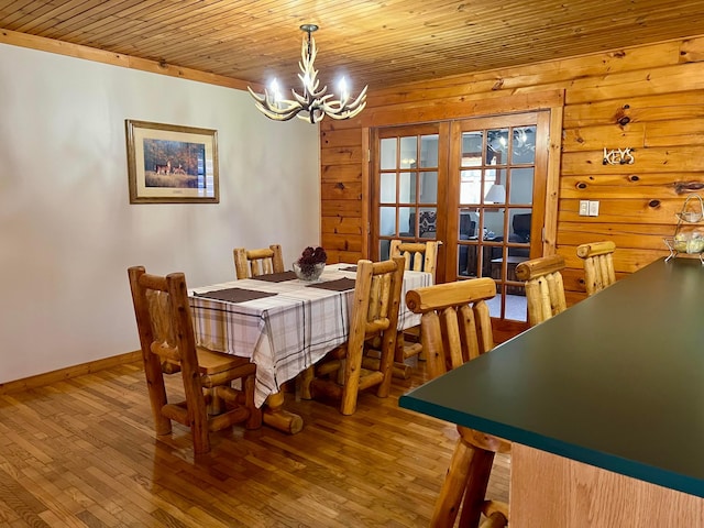 dining area featuring hardwood / wood-style flooring, a chandelier, and wooden ceiling