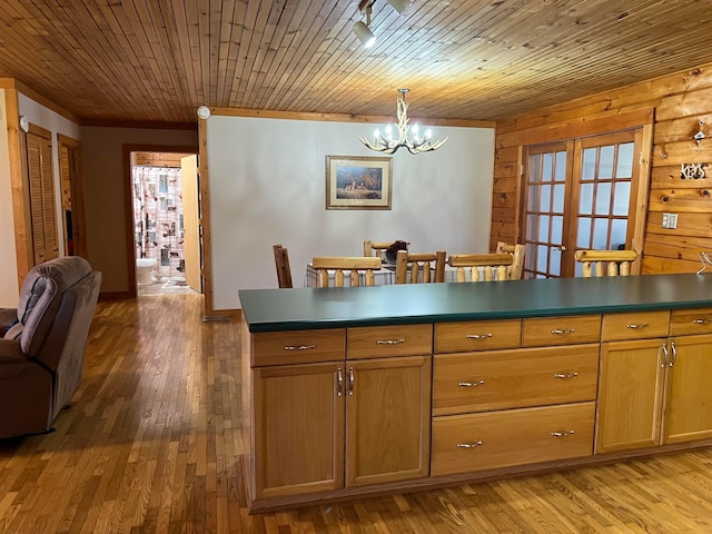 kitchen with an inviting chandelier, hanging light fixtures, light hardwood / wood-style floors, and wooden ceiling