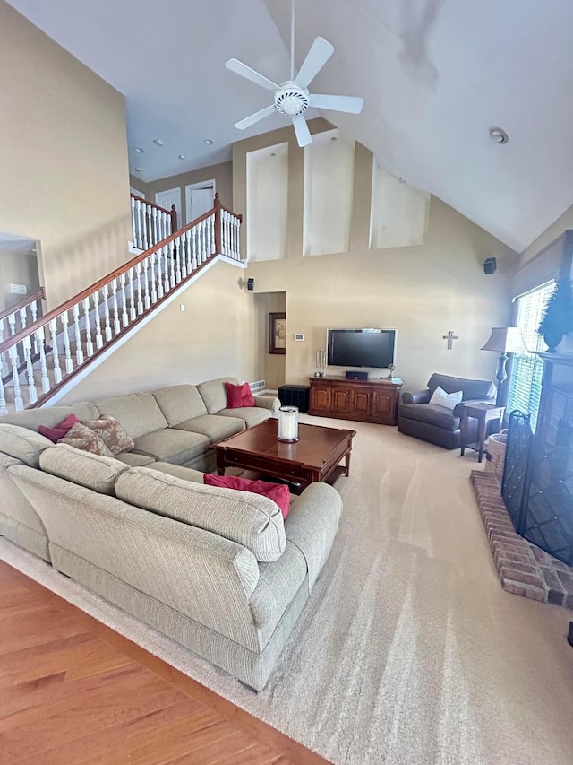 carpeted living room featuring ceiling fan and high vaulted ceiling