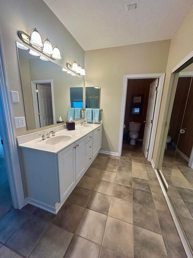 bathroom featuring vanity, toilet, and a textured ceiling