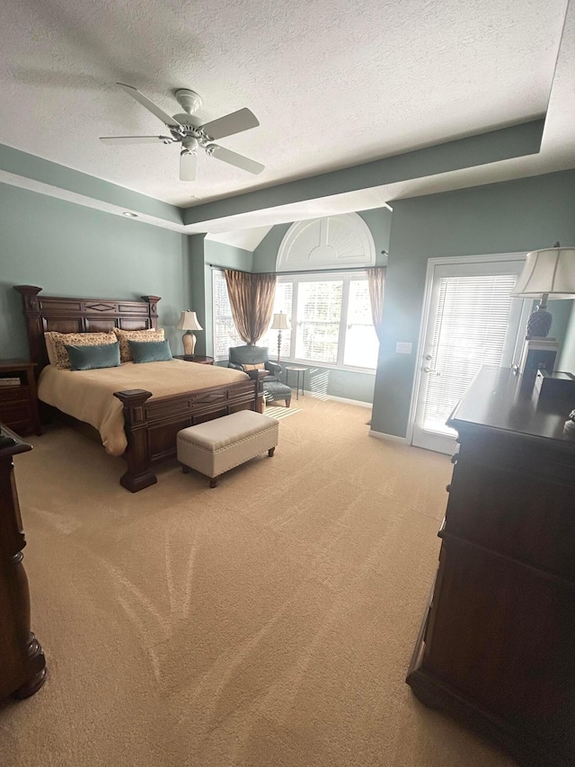 bedroom with ceiling fan, carpet floors, and a textured ceiling