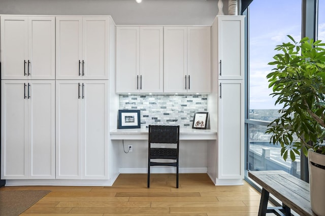 office space featuring built in desk and light wood-type flooring