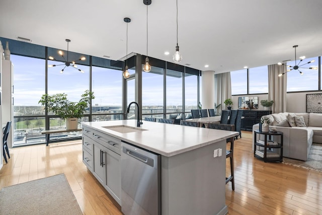 kitchen with a chandelier, a wall of windows, dishwasher, and sink