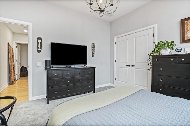 carpeted bedroom featuring a chandelier and a closet