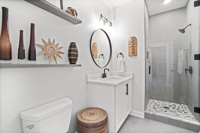 bathroom with tile patterned floors, vanity, toilet, and a shower with door