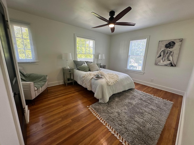 bedroom with ceiling fan, dark hardwood / wood-style flooring, and multiple windows