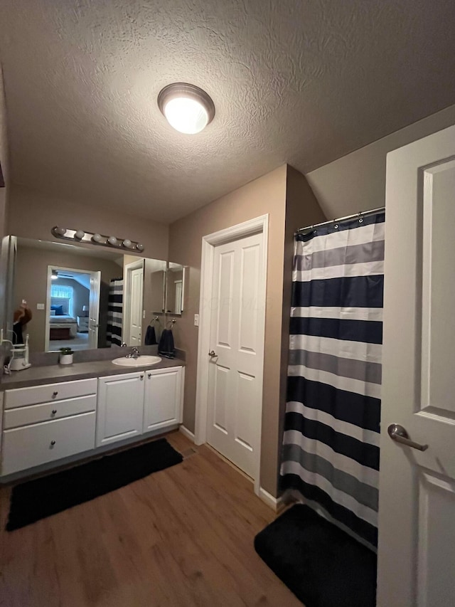 bathroom featuring hardwood / wood-style flooring, vanity, and a textured ceiling