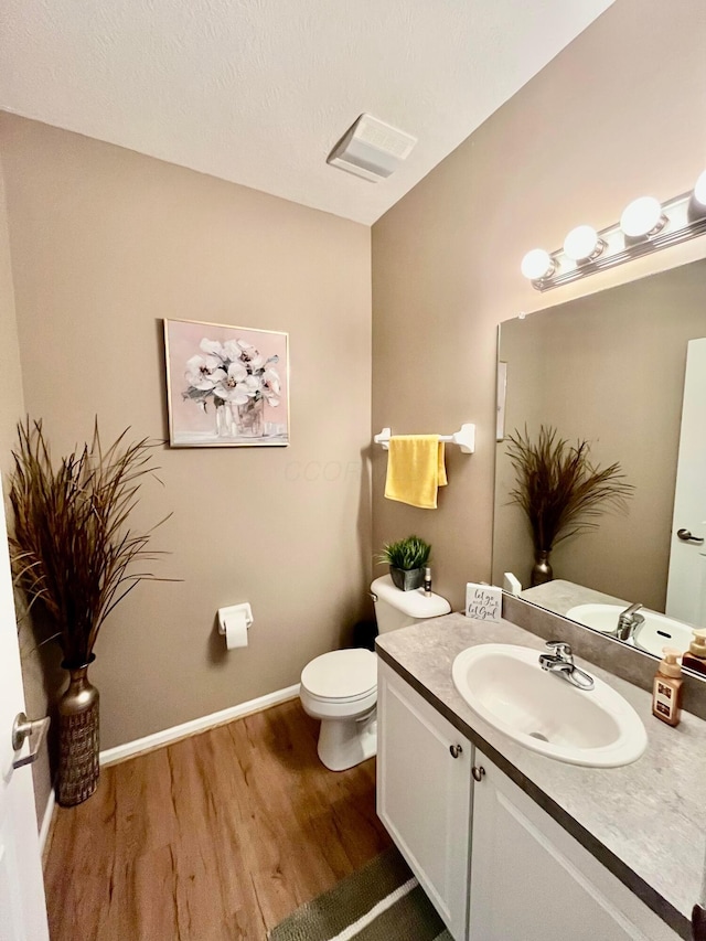 bathroom featuring hardwood / wood-style flooring, vanity, and toilet