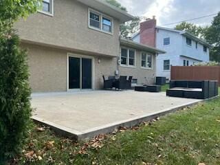 rear view of house with central AC unit, a lawn, and a patio