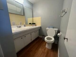 bathroom with hardwood / wood-style flooring, vanity, and toilet