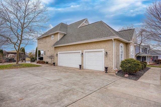 view of side of home featuring a garage and a gazebo