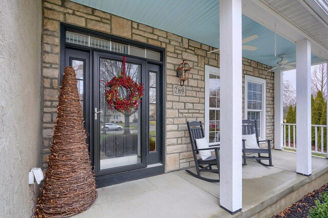 property entrance with ceiling fan and a porch