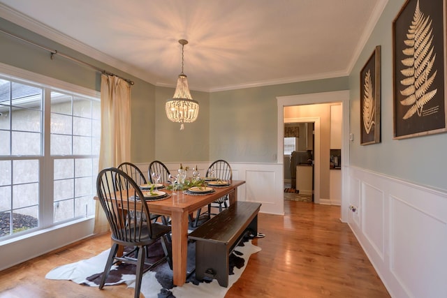 dining room featuring an inviting chandelier, ornamental molding, and light hardwood / wood-style floors