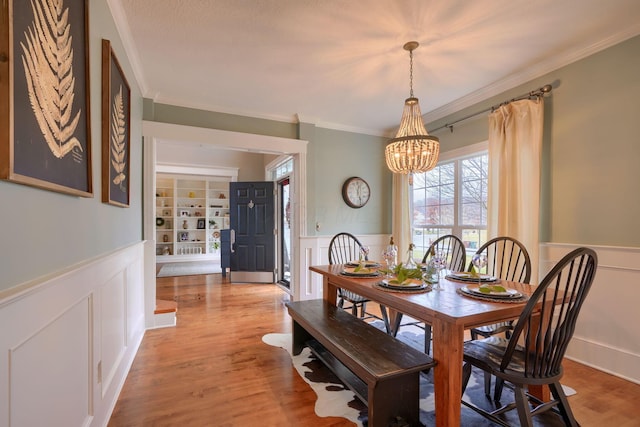 dining room featuring an inviting chandelier, crown molding, and light wood-type flooring