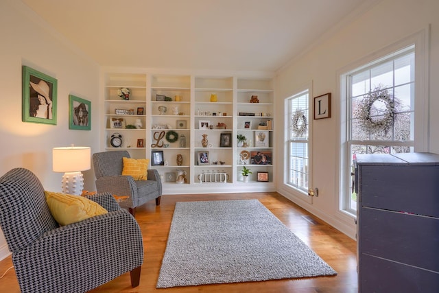 living area featuring ornamental molding and light wood-type flooring