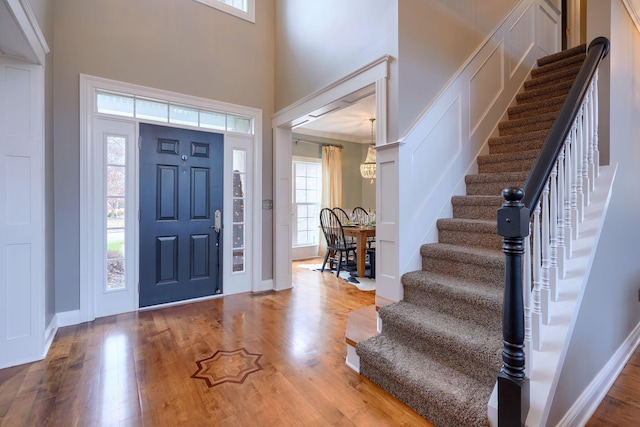 entrance foyer with hardwood / wood-style floors and a towering ceiling