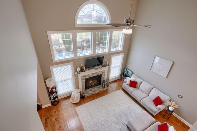 living room featuring a healthy amount of sunlight, light hardwood / wood-style flooring, and a high ceiling