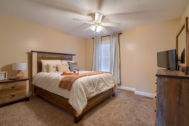 bedroom with ceiling fan, carpet floors, and a textured ceiling