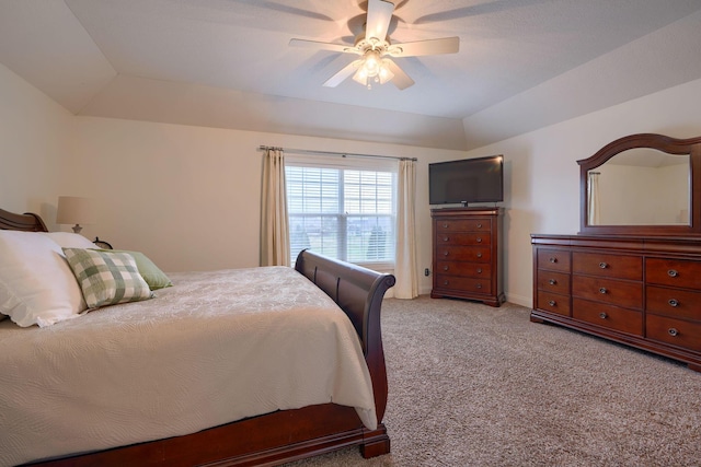 carpeted bedroom with ceiling fan and a raised ceiling