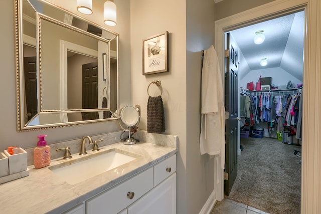 bathroom with lofted ceiling and vanity