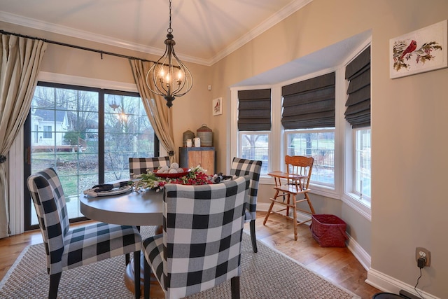 dining area with an inviting chandelier, hardwood / wood-style flooring, and ornamental molding