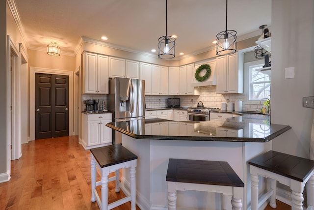 kitchen featuring sink, a breakfast bar, stainless steel appliances, white cabinets, and kitchen peninsula