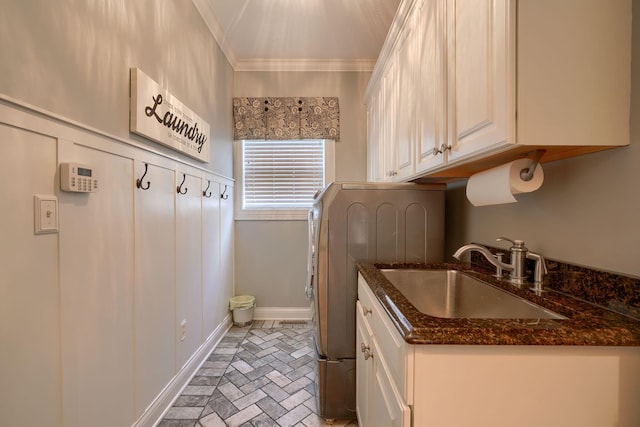 washroom with crown molding, cabinets, washer / clothes dryer, and sink