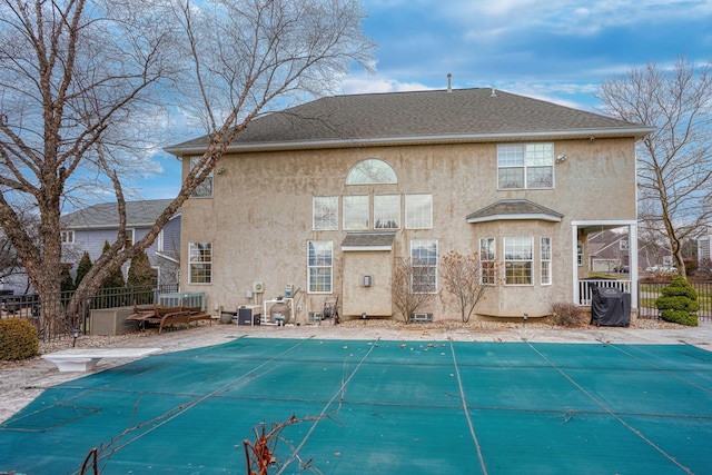 rear view of property featuring a patio area and a covered pool