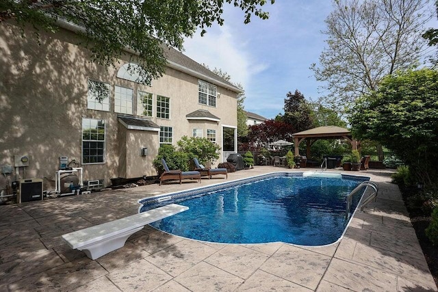 view of pool with a gazebo, a diving board, and a patio