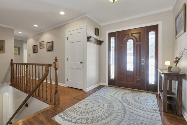 entryway with ornamental molding and dark hardwood / wood-style flooring