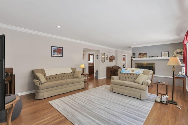 living room with crown molding, a fireplace, and hardwood / wood-style floors