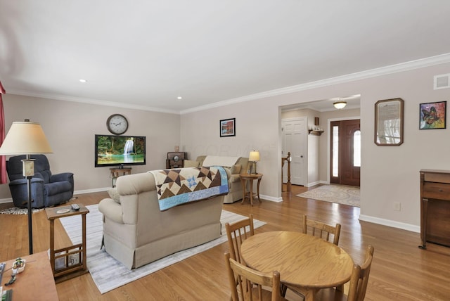 living room featuring crown molding and light hardwood / wood-style flooring