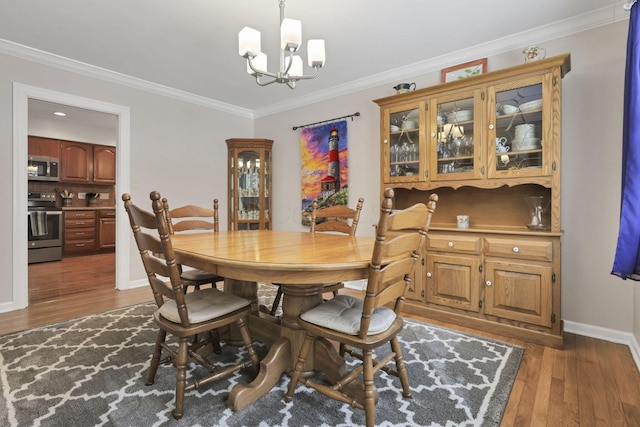 dining room with ornamental molding, dark hardwood / wood-style flooring, and a chandelier