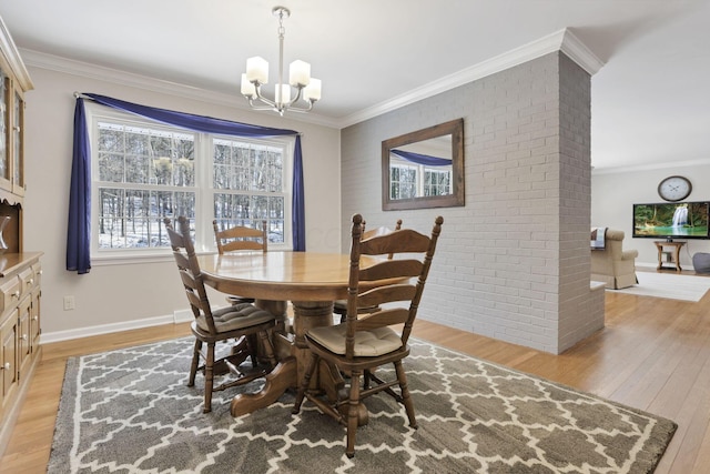 dining area with crown molding, brick wall, an inviting chandelier, and light wood-type flooring