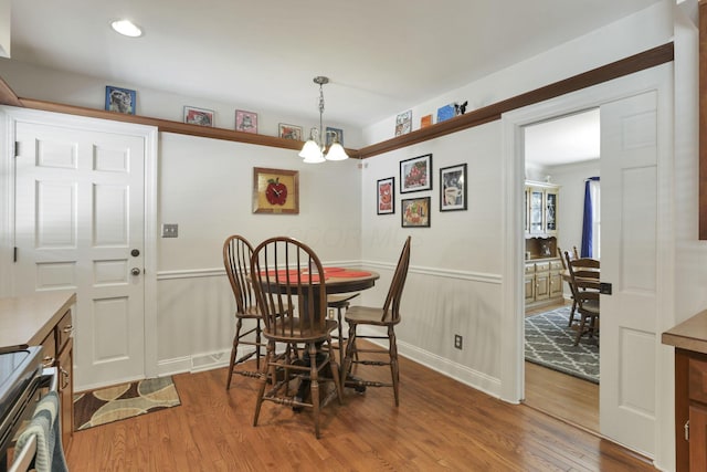 dining space featuring hardwood / wood-style floors and a chandelier