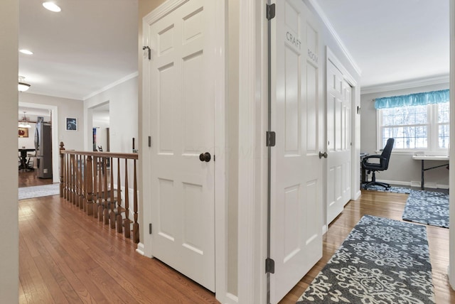 corridor with ornamental molding and wood-type flooring