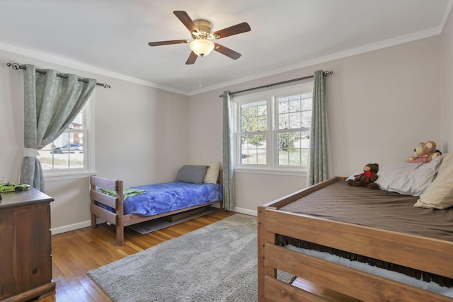 bedroom featuring ceiling fan, ornamental molding, and hardwood / wood-style floors