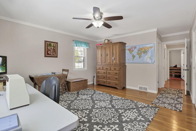 office featuring ceiling fan, ornamental molding, and light hardwood / wood-style flooring