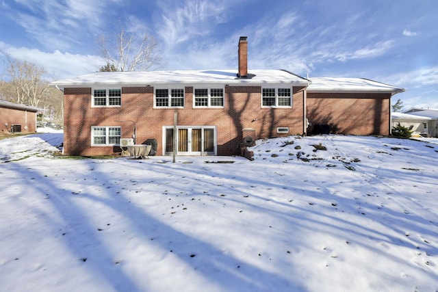 view of snow covered back of property