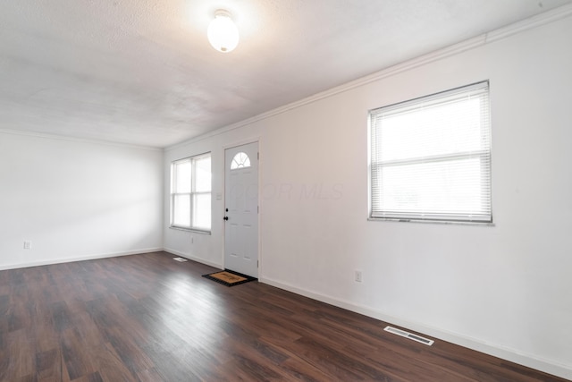 entrance foyer with crown molding, dark hardwood / wood-style floors, and a textured ceiling