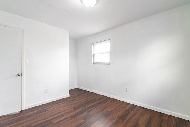 empty room with dark wood-type flooring