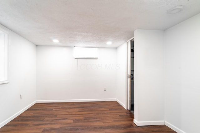 spare room with dark hardwood / wood-style floors and a textured ceiling