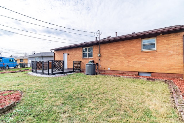 rear view of house featuring cooling unit and a lawn