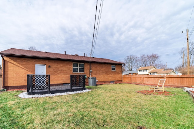 rear view of property with a yard and central AC