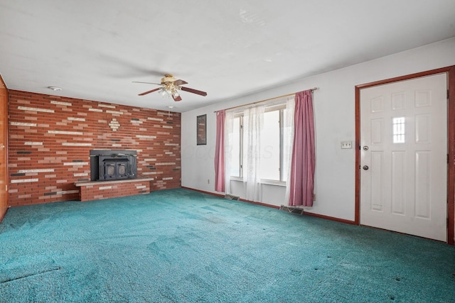 unfurnished living room with ceiling fan, carpet, and a wood stove