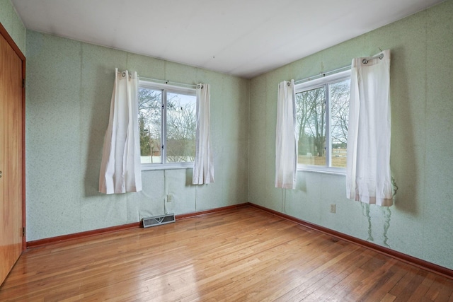 unfurnished room featuring plenty of natural light and light hardwood / wood-style floors