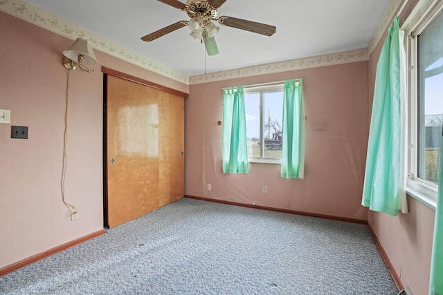 carpeted spare room featuring ceiling fan